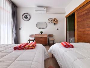 een slaapkamer met twee bedden, een bureau en een spiegel bij Villanarachaam in Cha Am +28 foto's