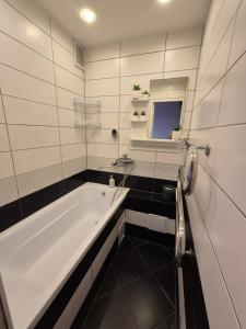 a bathroom with a bath tub and a sink at Butas in Mažeikiai