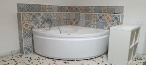 a white tub in a bathroom with a tiled wall at Happy House Herculaneum in Ercolano +10 photos