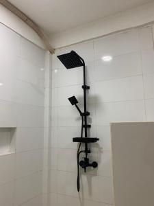 a shower stall with a shower head on the wall at Bale Hotel & Cowork in Kuta Lombok
