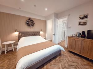 een slaapkamer met een groot bed en een televisie bij The Mews Room at The Coach House in Windermere