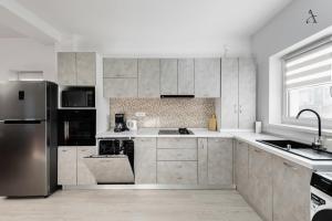 a kitchen with a stainless steel refrigerator and cabinets at City Gardens Villa in Otopeni