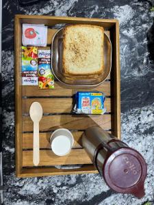 un plateau en bois avec un plateau de pain et un couteau dans l'établissement WKND Casa, à Panchgani