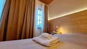 a bedroom with a bed with white towels on it at Da Nonna Isa - Ampio appartamento tra Bormio e Bernina Express in Grosotto