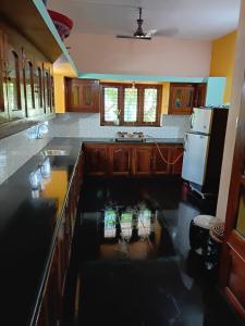 a kitchen with a sink and a refrigerator at Stay by Asharaf AS Villa in Varkala