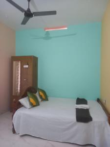 a bedroom with a bed with a ceiling fan at Stay by Asharaf AS Villa in Varkala