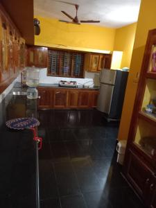 a kitchen with wooden cabinets and a stainless steel refrigerator at Stay by Asharaf AS Villa in Varkala +4 photos