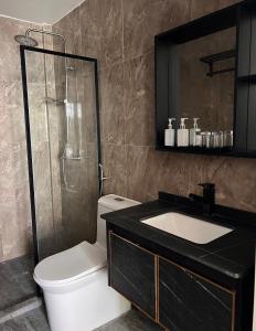 a bathroom with a toilet and a sink and a shower at Alma Maldiva, Beach Hotel in Ariyaddu