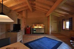 Sala de estar de una cabaña de madera con alfombra azul en Sonnenplatzl im Zillertal, en Ramsau im Zillertal