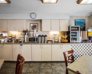 een keuken met witte kasten en een klok aan de muur bij Econo Lodge Denver International Airport in Aurora