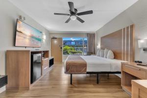 a hotel room with a bed and a flat screen tv at Rodeway Inn & Suites Fort Lauderdale Airport & Cruise Port in Fort Lauderdale