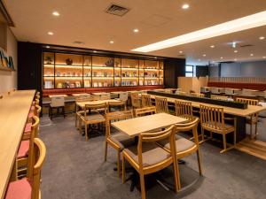 ein Restaurant mit Holztischen, Stühlen und Regalen in der Unterkunft Comfort Hotel ERA Kyoto Toji in Kyoto