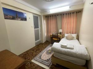 DND House في باتان: غرفة نوم صغيرة بها سرير ومكتب