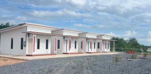 een groot wit gebouw met rode en zwarte ramen bij Saint Jira Hotel in Chum Phae