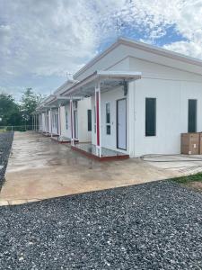 een groot wit gebouw met veel kraampjes bij Saint Jira Hotel in Chum Phae +3 foto's