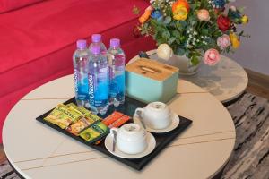 a table with bottles of water and a vase with flowers at APEC Mandala Mũi Né VIP in Mui Ne