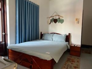 een slaapkamer met een bed met een blauw gordijn bij Tulip Mui Ne in Phan Thiet