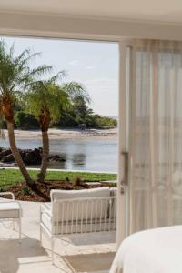 a bedroom with a view of the ocean from a beach at Nomaya Waterfront Getaway in Currarong