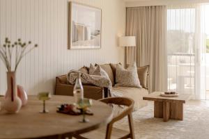 a living room with a couch and a table at Nomaya Waterfront Getaway in Currarong