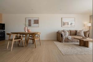 a living room with a table and a couch at Nomaya Waterfront Getaway in Currarong