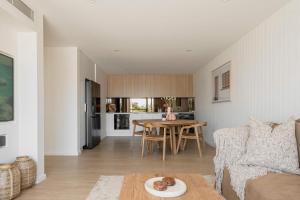 a living room with a table and a couch at Nomaya Waterfront Getaway in Currarong +31 photos