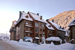 un gran edificio de ladrillo con nieve en el suelo en Val de Ruda Luxe 1 by FeelFree Rentals, en Baqueira Beret