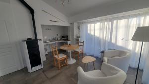 un salon avec une table et des chaises et une cuisine dans l'établissement Balade Océane, à Loctudy