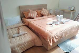 a large bed with two stuffed animals on it at ณิชาวิลล่า ริเวอร์ฟร้อนท์ บ้านท่าตอน Nicha Villa Riverfront BanThaton in Mae Ai Chiang Mai