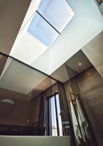 a bathroom with a mirror and a window and towels at Moderninfluence - Aparthotel in Porto
