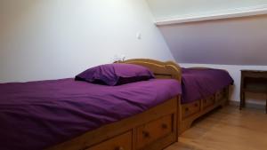 a bedroom with a bed with purple sheets at Gîte de l'Eure in Léry +22 photos