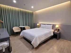 a hotel room with a bed and a table and chairs at 호텔휴 