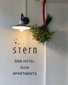 a sign hanging on a wall with a light at Stern B&B & Suite Apartments in Nova Levante