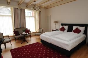a bedroom with a large bed and a red rug at De Gulden Waagen in Nijmegen