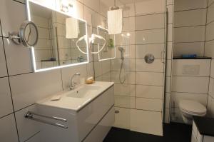 a white bathroom with a sink and a shower at De Gulden Waagen in Nijmegen +80 photos