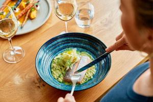 a woman sitting at a table with a bowl of food at Falkensteiner Hotel Bad Leonfelden l Adults Only l 4 Star Superior in Bad Leonfelden +28 photos