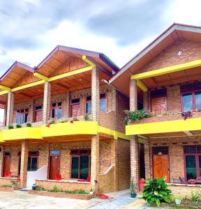 een groot bakstenen gebouw met gele balkons. bij Donny Guesthouse in Tuk Tuk