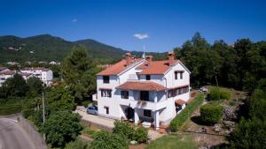 une grande maison blanche avec un toit rouge dans l'établissement Apartments Kinkela, à Opatija