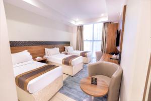 um quarto de hotel com duas camas e um sofá em فندق ميزاب السابق 2 em Meca mais 88 fotografias
