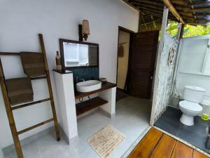 a bathroom with a sink and a toilet at RNV Eco Resort Bungalows in Batukaras +144 photos