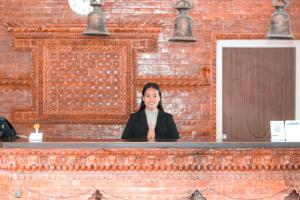 een vrouw zit aan een toonbank in een bakstenen muur bij Center Park Resort Pvt.Ltd in Jhawāni +23 foto's