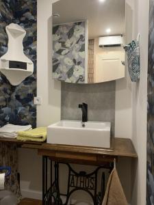 een badkamer met een wastafel en een spiegel bij atelier couture in Reiningue