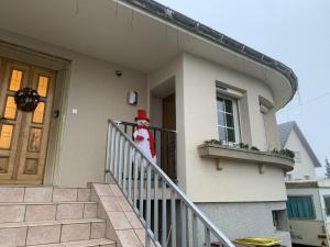 een kerstman die op de reling van een huis staat bij atelier couture in Reiningue