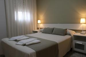 a bedroom with a bed with two pillows on it at Apartamentos Bolonia Paraiso in Bolonia +37 photos