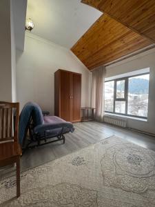 a living room with a bed and a large window at Жайсан in Karakol