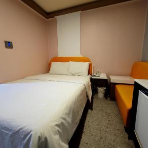 a small room with a bed and two orange chairs at 스카이모텔 in Seoul +3 photos
