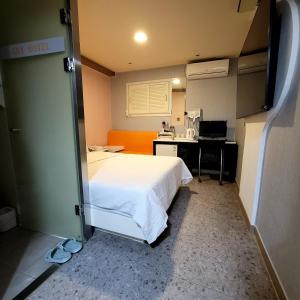 a bedroom with a white bed and a desk at 스카이모텔 in Seoul