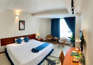 een hotelkamer met een groot bed en een tafel bij The Coast Hotel Vung Tau in Vung Tau +52 foto's