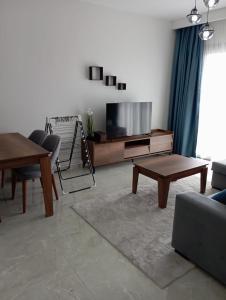 a living room with a tv and a table at Rıversıdelıfe Iskele M 147 in Aglantzia