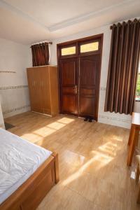 ein Schlafzimmer mit einem Bett und einem Holzboden in der Unterkunft Thuận Phát Motel Bình Dương in Thuan An