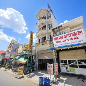 ein Gebäude mit einem Schild am Straßenrand in der Unterkunft Thuận Phát Motel Bình Dương in Thuan An